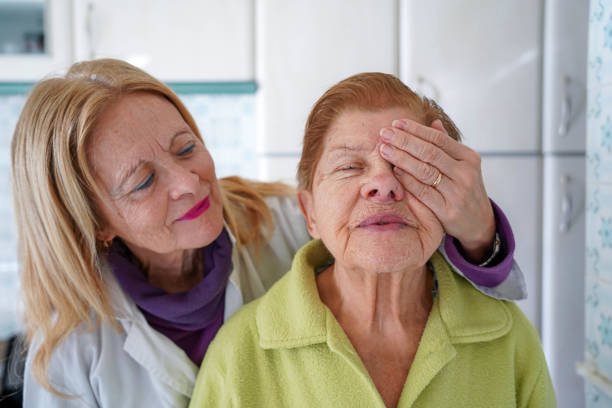 Tender scene of an ophthalmologist covering an old woman's eye